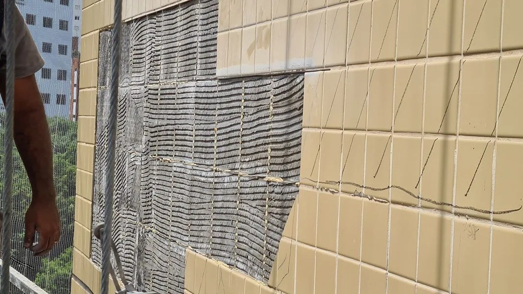 Fachada com cerâmica descolada expondo a argamassa colante